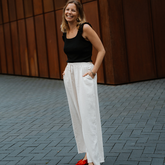 JU MAKE IT HAPPEN Webagentur Gründerin Julia Tutsch lächelnd vor moderner Wand – Website & E-Commerce Beratung